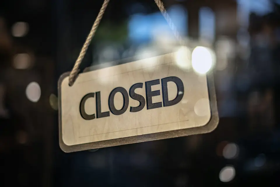Panneau Closed suspendu derrière une porte vitrée